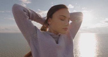 Slow Motion, güzel kadın uzun saçlarına dokunuyor harika deniz ve gökyüzünün üzerindeki tepenin üstünde duruyor