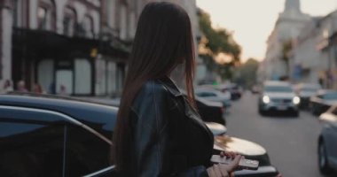 Kadın caddede akıllı telefon kullanırken karşıdan karşıya geçiyor, ağır çekim.