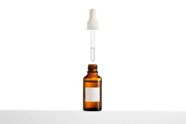 Beyaz arka plan üzerinde pipet ile cam şişe