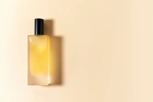 Butelka perfum na beżowym tle z twardym cieniem — Zdjęcie stockowe