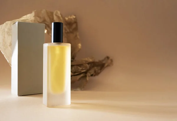 Parfumflesje en verpakking op beige — Stockfoto