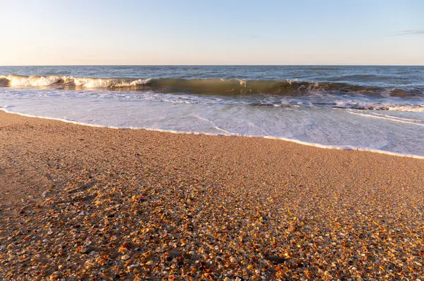 Sarı kumda gün batımında el salla. Hazar Denizi.