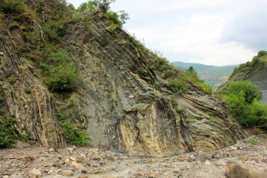 Nehrin kıyısındaki ormanda güzel bir kaya. Lahij köyü. Azerbaycan.