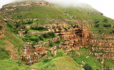 Vadide kızıl dağları olan güzel bir şelale. Gryz köyüne giden yol. Guba bölgesi. Azerbaycan.