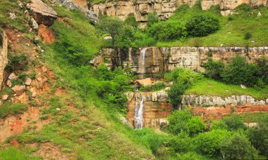 Vadide kızıl dağları olan güzel bir şelale. Gryz köyüne giden yol. Guba bölgesi. Azerbaycan.