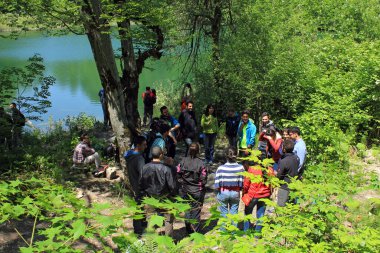 Shabran bölgesi. Azerbaycan. 05.22.2016. İnsanlar dağların tepesinde mavi bir gölde oyun oynuyorlar..