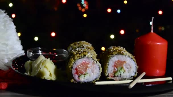 New Year Still Life Burning Candle Sushi Blinking Christmas Lights — Stock Video