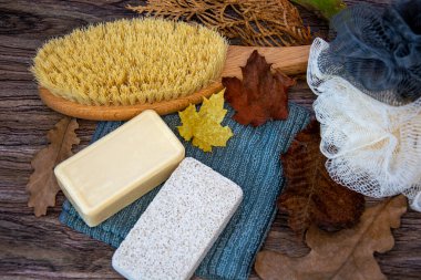 Sünger taşı, sabun, vücut fırçası ve lif. Sonbahar yapraklarında banyo aksesuarları.