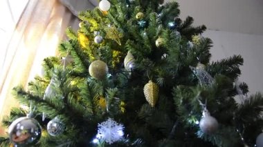 Tall Christmas tree with toys. We celebrate the New Year at home. Christmas, winter, New Year.