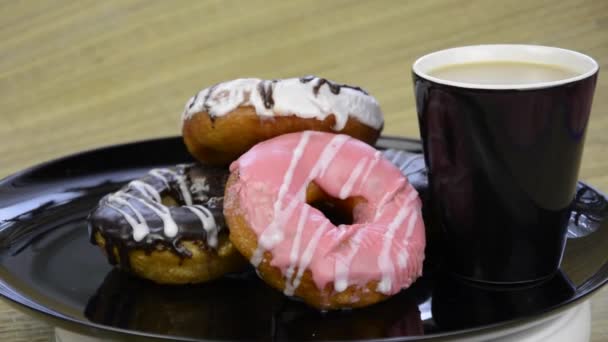 Een Donut Donuts Chocolade Glazuur Cupcakes Een Zwarte Plaat — Stockvideo