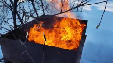 Metal bir fıçıda yangın. Kışın demir bir konteynırda çöp yakmak. Geri dönüşüm.