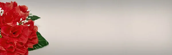 Beyaz arka planda suni kırmızı güllerin dekoratif buketine yakın çekim.