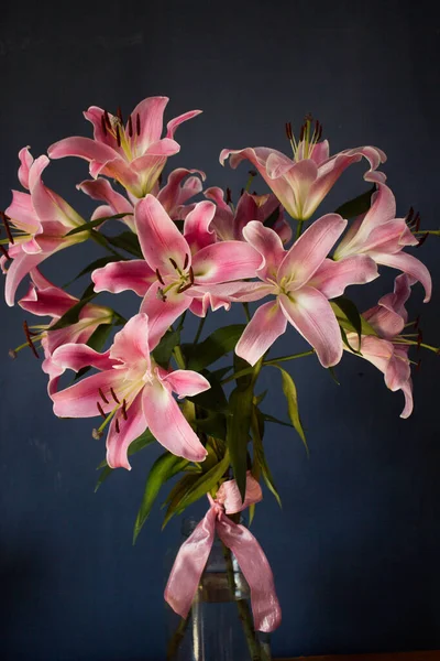 Beautiful bouquet of flowers. Lilies on a dark background. Background. Texture.