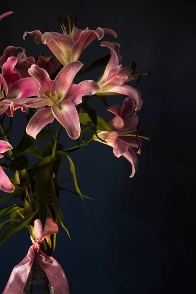 Beautiful bouquet of flowers. Lilies on a dark background. Background. Texture.