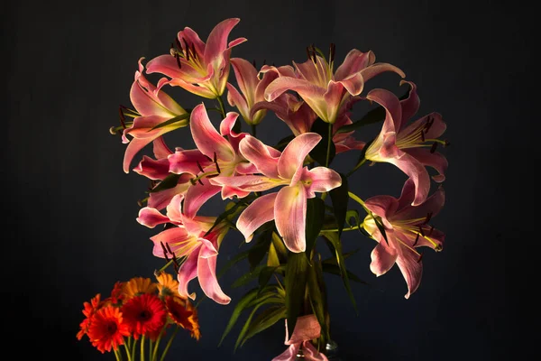 Beautiful bouquet of flowers. Lilies on a dark background. Background. Texture.