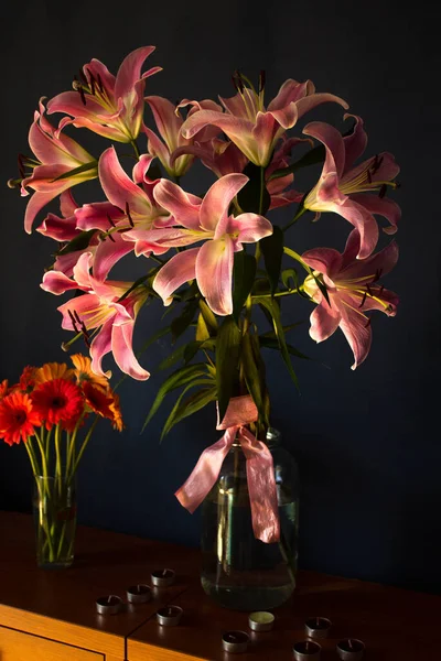 Beautiful bouquet of flowers. Lilies on a dark background. Background. Texture.