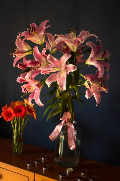 Beautiful bouquet of flowers. Lilies on a dark background. Background. Texture.