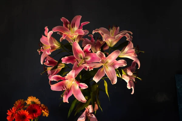 Beautiful bouquet of flowers. Lilies on a dark background. Background. Texture.