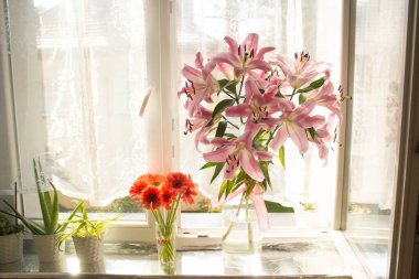 A beautiful bouquet of flowers on the window. Lilies on the window. Background. Texture.