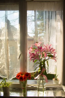 A beautiful bouquet of flowers on the window. Lilies on the window. Background. Texture.