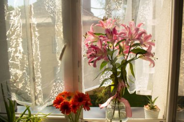 A beautiful bouquet of flowers on the window. Lilies on the window. Background. Texture.