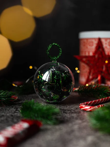 Πρωτοχρονιάτικη μπάλα με γλυκά. Χριστουγεννιάτικο φόντο, ζωντανά κλαδιά ελάτης. Χριστουγεννιάτικα στολίδια. Εικόνα Αρχείου