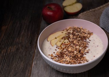 Yunan yoğurtlu sağlıklı kahvaltı kasesi, püre taze elma, kızarmış yulaf ezmesi ve keten tohumu.