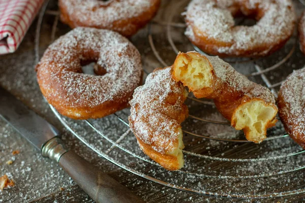 Lezzetli, taze kızartılmış hamur tatlısı ya da soğutma rafında sıcak servis edilen ahşap masada pudra şekerli börek..