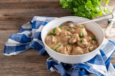 Traditional homemade cooked kttbullar, swedish meatballs in a delicious cream sauce. Served on wooden and rustic table with copy space. 