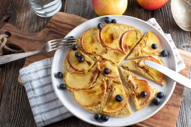 Elmalı yulaflı gözleme. Yulaf ezmesi ve elma dilimiyle pişirilmiş lezzetli ve sağlıklı kahvaltı gözlemesi. Kırsal ve ahşap masa zemininde servis edilmiş. Tablo üstü görünümü