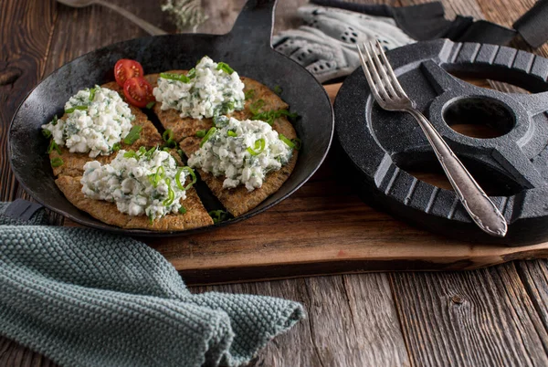 High protein fitness breakfast for sports nutrition with homemade fresh pan baked oatmeal pancake. Topped with cottage cheese salad and served with dumbbell on rustic and wooden table background