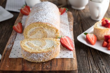 Krem şanti ve çilekli bisküvi. Köy ve ahşap masa arka planında kesit görüntüsüyle servis ediliyor. Ön görünüm