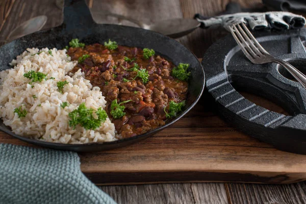 Body building meal with low fat ground beef, kidney beans, vegetables and tomato sauce. Served with brown rice. Chili con carne fitness dish