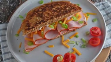 Healthy sandwich made with oatmeal pancake. Topped with thin sliced turkey breast and cheddar cheese. Real time and zoom out effect