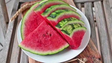 Taking a piece of watermelon from a plate