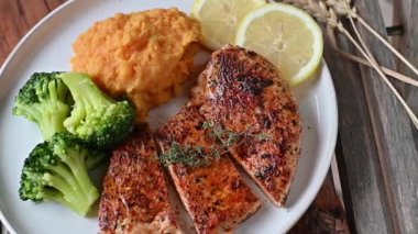 Delicious homemade cooked meal for fitness, dieting or healthy eating with a fried turkey breast. Served with pumpkin puree and broccoli on a plate