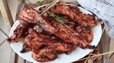 Womans hand takes a fresh grilled turkey steak from a plate