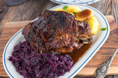 Holiday roast with roasted turkey shank, red cabbage, boiled potatoes and delicious brown gravy,