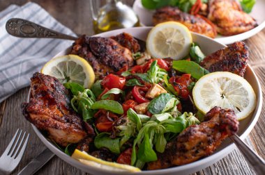 Barbecue chicken legs with a delicious salad for side dish. Served ready to eat on rustic and wooden table