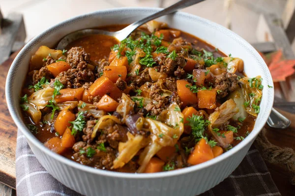 Traditional homemade ground beef stew with cabbage, carrots, tomatoes, onions and herbs.