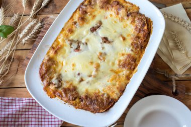 Lasagne with bolognese, bechamel sauce and mozzarella cheese topping in a white casserole dish