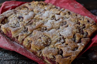 Plum cake with crumbles on wooden table. Traditional german plum crumble cake fresh and homemade baked