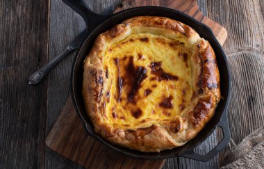 Limon kaymaklı puf böreği dökme demir bir tavada pişirildi ve ahşap masada izole olarak servis edildi. Üst görünüm