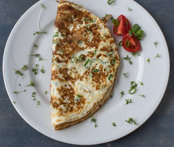 Tahta arka planda izole edilmiş beyaz bir tabakta yumurta beyazı omlet. Yakın çekim ve genel görünüm