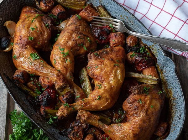 Braised chicken legs with root vegetables in a rustic roasting pan. Delicious oven dish fresh and homemade cooked