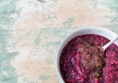 Tahta masada izole edilmiş, içinde elma, yaban mersini ve tarçın bulunan sağlıklı meyve tatlısı.