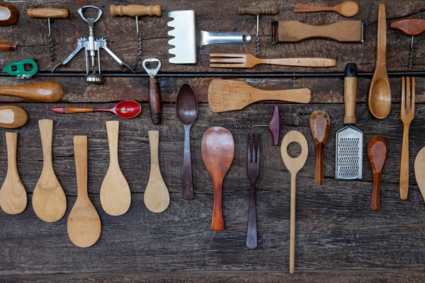Mutfak aletleri düz ahşap masa üzerine dizayn edildi kaşık, spatula, tirbuşon, yemek aletleri kullanımı için peynir rendesi dahil