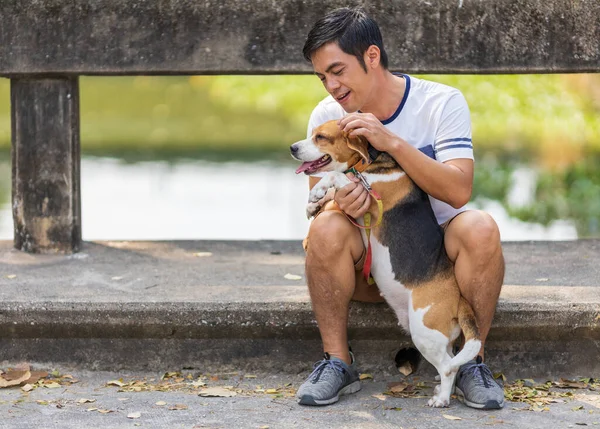 亚洲人在公园晨练时 正在和他的小猎犬玩耍 — 图库照片