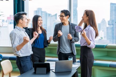 Genç Asyalı girişimciler ve girişimciler iş toplantısı yapıyorlar ve başarılı pazarlama konsepti için birbirlerini iyi enerji için teşvik ediyorlar.