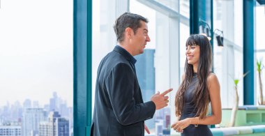 İdari işadamı ve sekreteri şehir merkezindeki modern gökdelen ofisinde çalışıyor. İş yatırım hayalleri ve gelecekteki vizyonları için gökdelen manzaralı pencereden bakıyorlar.